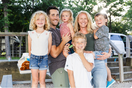 Happy UK family wearing colourful DEET-free mosquito patches outdoors